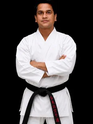 Chief Instructor Sensei Amit More wearing a clean white gi, looking disciplined and focused.